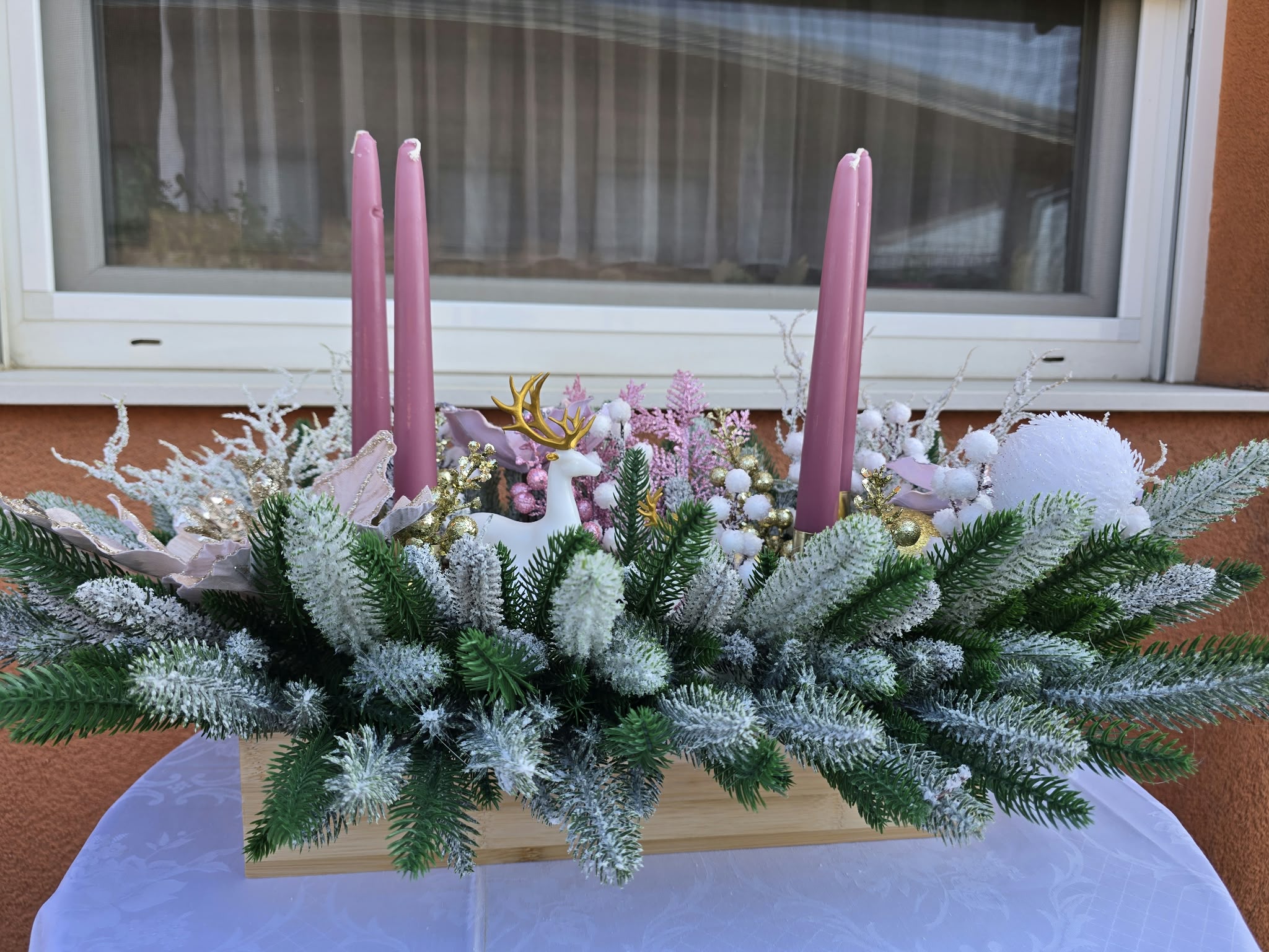 Detalj magnolija i zlatnog irvasa na pastelnom adventskom vijencu
