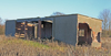 Two huts each side connected by a rear wall and an overhanging roof to shoot from.