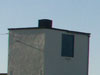 A water tower with heating chimney and doors on the water tank space.