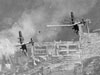 Vertical aerial photograph taken during a daylight attack on German warships docked at Brest, France. Two Handley Page Halifax’s of No. 35 Squadron RAF fly towards the dry docks in which the battle cruisers SCHARNHORST and GNEISENAU are berthed , and over which a smoke screen is rapidly spreading. © IWM (C 4109).