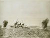 A Battleship being shelled from a shore batterie off Normandy.