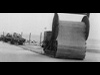 Churchill Roly-Poly or Bobbin tanks laying a flexible roadway across soft sand/clay on Gold beach..