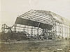 Steel framed airship hangar being demolished.