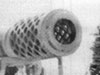 Muzzle break, when the gun is fired, the barrel recoils backwards. By adding a muzzle break, hot gasses shoot out backwards out of its holes  as the shell passes and for a fraction of a second. That  slows the barrels travel. Thus allowing for a shorter carriage.