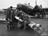 A bomber crew of No. 311 (Czechoslovak) Squadron RAF study a map, while sitting on 250-lb GP bombs which are about to be loaded into their Vickers Wellington Mark IC at East Wretham, Norfolk.