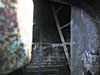 Looking into another Flak tower , this one has a metal ladder on others concrete stairs.