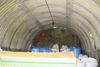 Inside what looks like a Nissen style hut made of curved asbestos sheets on brick walls to extend its height.