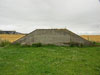 End wall to a berm of earth built around the store.