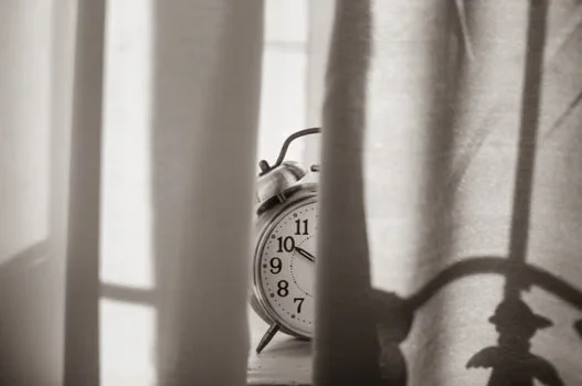 A clock hiding behind curtains
