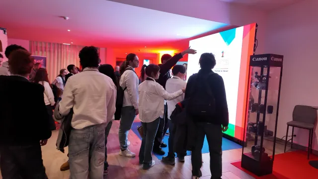 Participantes junto ao painel luminoso do 1.º Congresso Português dos Audiovisuais, ao lado do expositor da Canon
