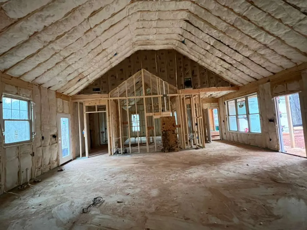 Spray foam on the roofline and walls of a new home before drywall
