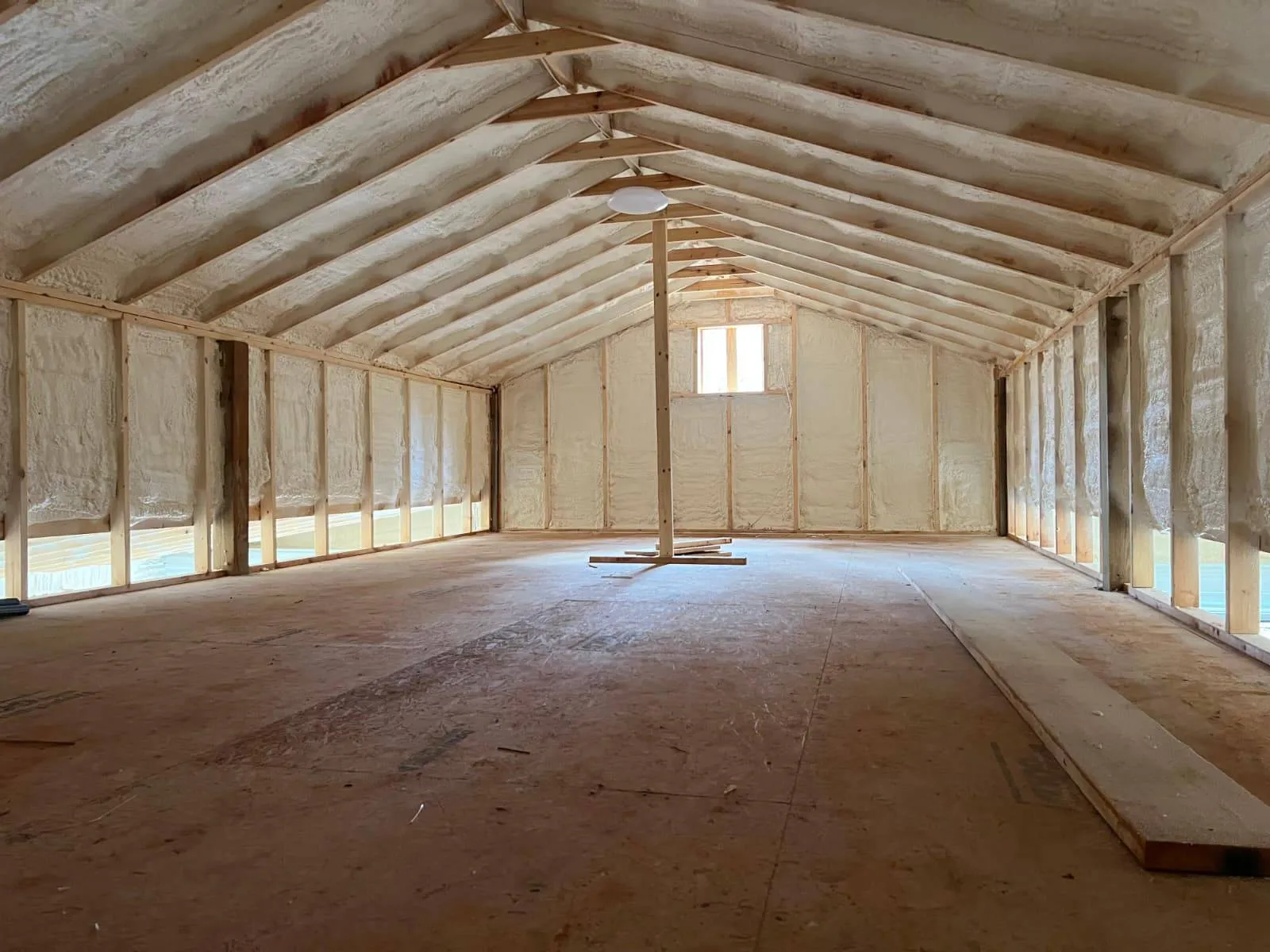 Spray foam insulation across a large vaulted room under construction