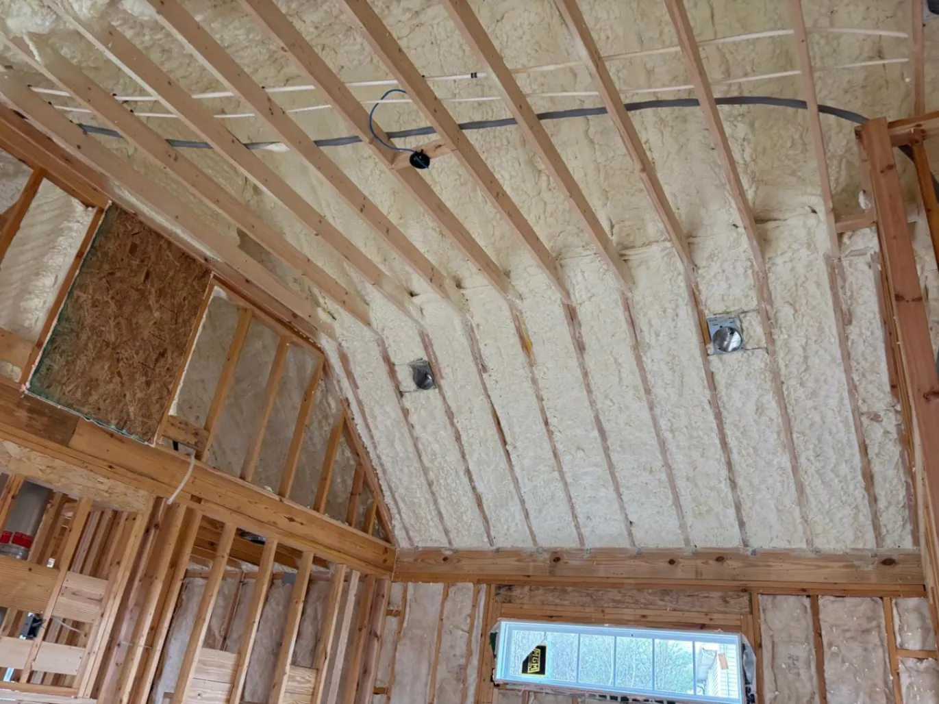 Spray foam insulation along a sloped ceiling and walls