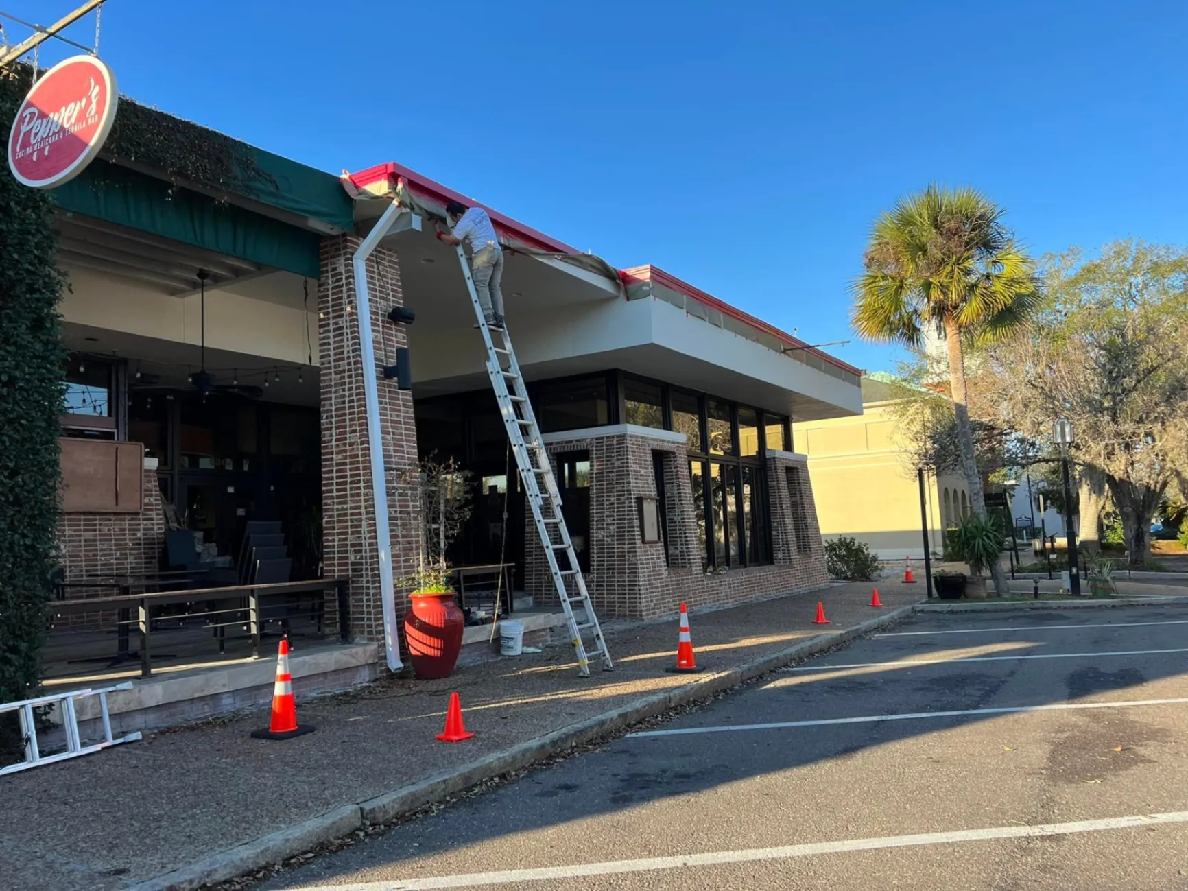 Commercial storefront under repaint with ladders and safety cones in front