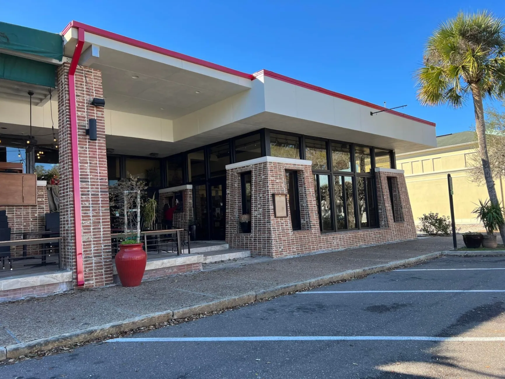 Brick storefront with a freshly painted entry canopy and trim after a commercial repaint