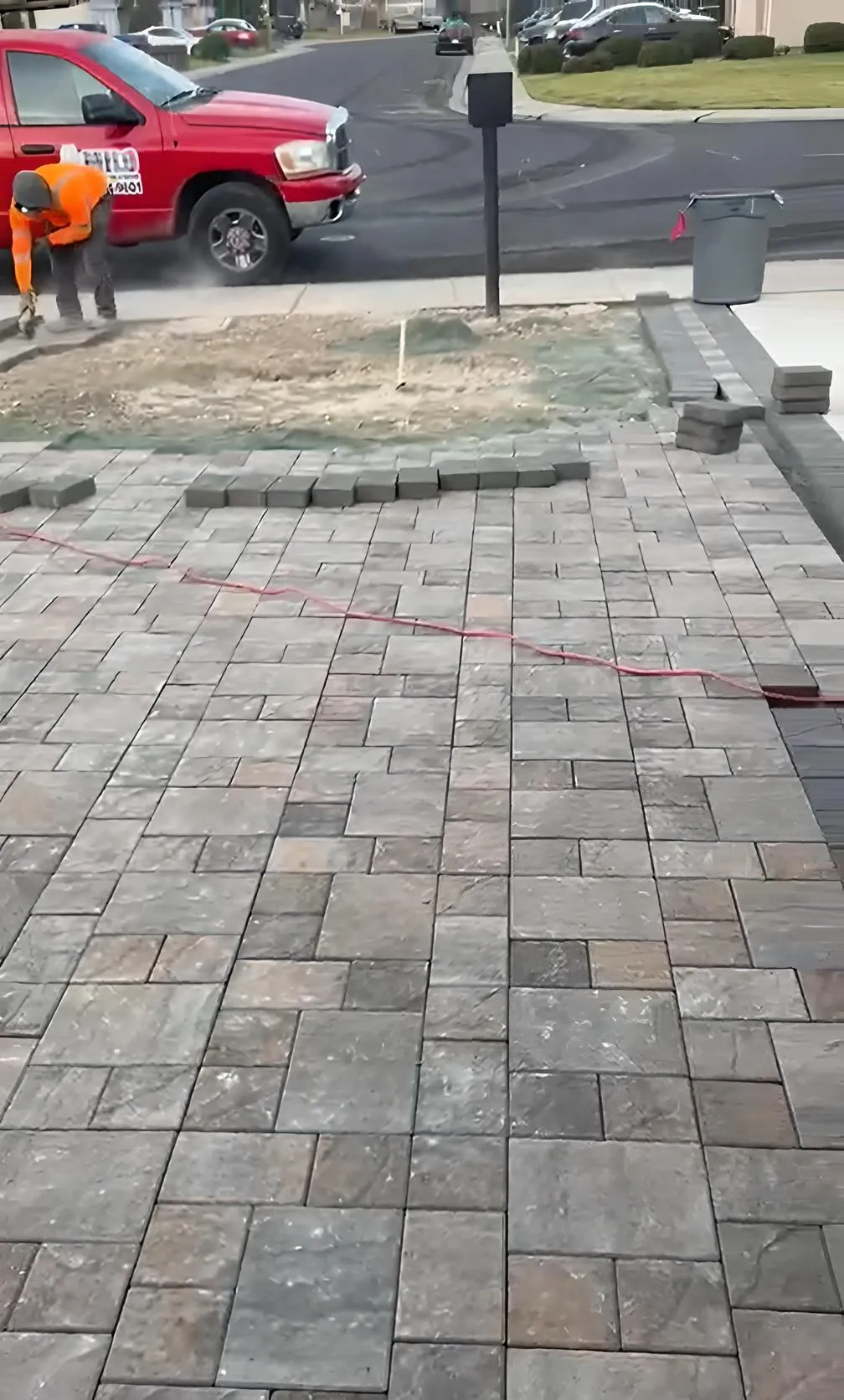 Newly installed gray blend paver driveway in front of a home