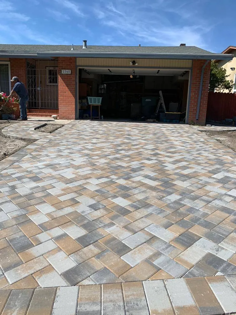 Herringbone paver driveway leading to a home's garage door