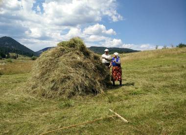 Straw pile with peasants at the mountains