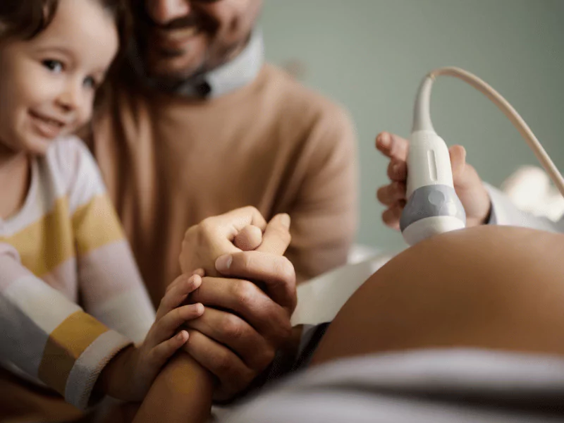 A mother holds and proudly displays a 4D ultrasound image, capturing her baby's detailed features in lifelike clarity