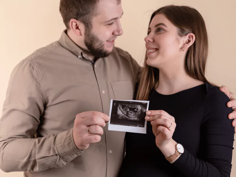 A mother holds and proudly displays a 4D ultrasound image, capturing her baby's detailed features in lifelike clarity