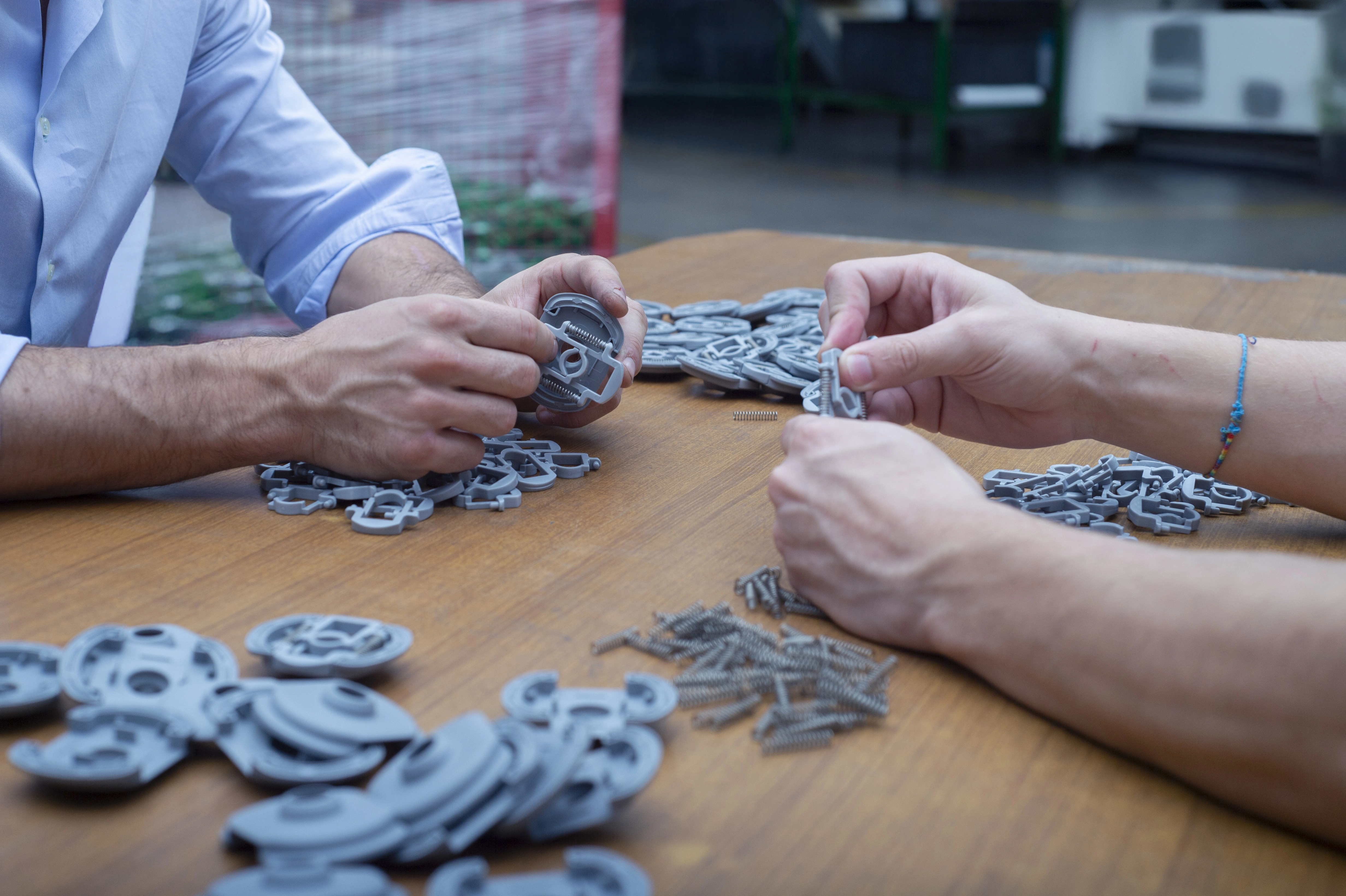 Foto che ritrae mani che assemblano pezzi in plastica