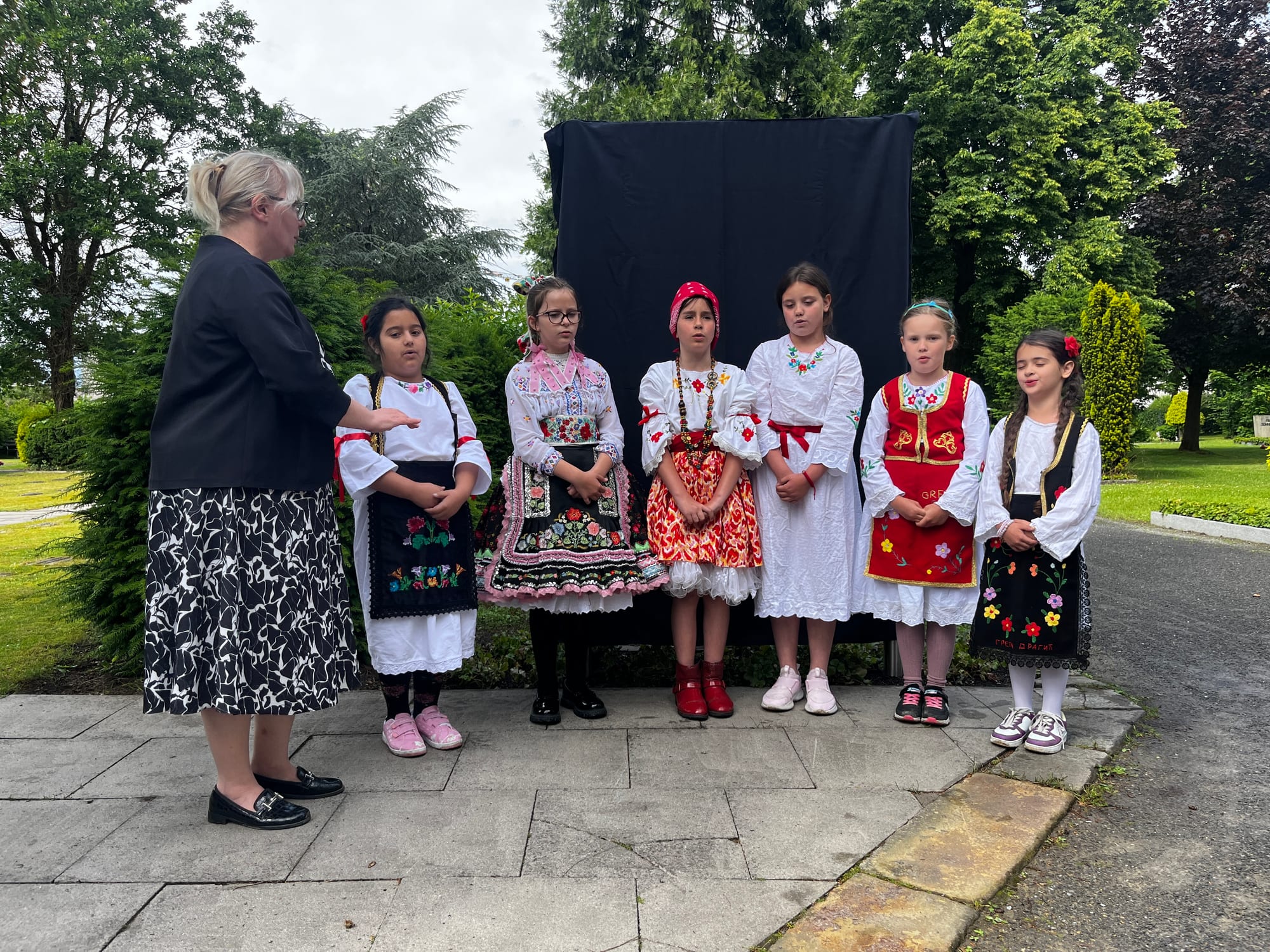 The youngest participants in folk costumes, led by teacher Zagorka Kričković, singing "Tamo daleko" at the Eversburg cemetery in Osnabrück