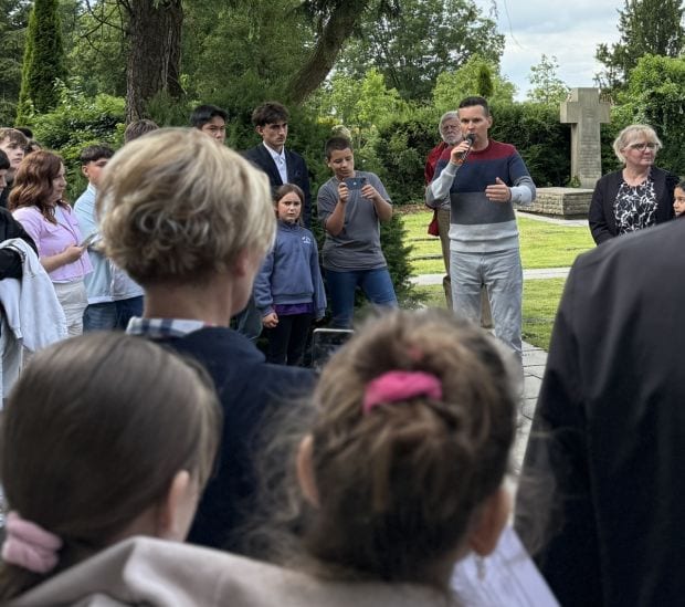 Dr. Željko Dragić addresses the young participants and guests at the Eversburg cemetery during the memorial ceremony