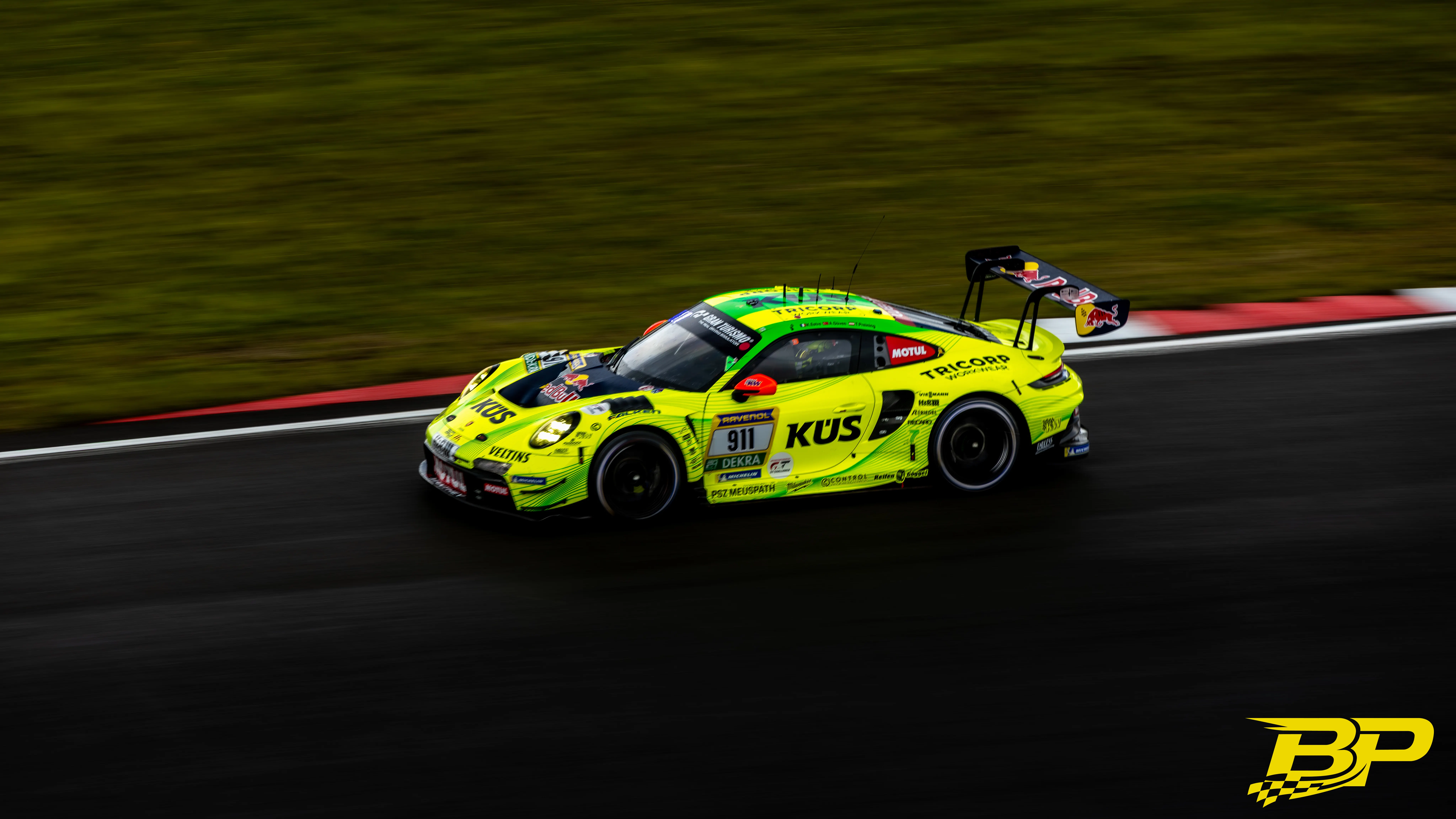 Neongelber Porsche 911 GT mit Startnummer 911 in einer Mitziehaufnahme auf der Nordschleife.