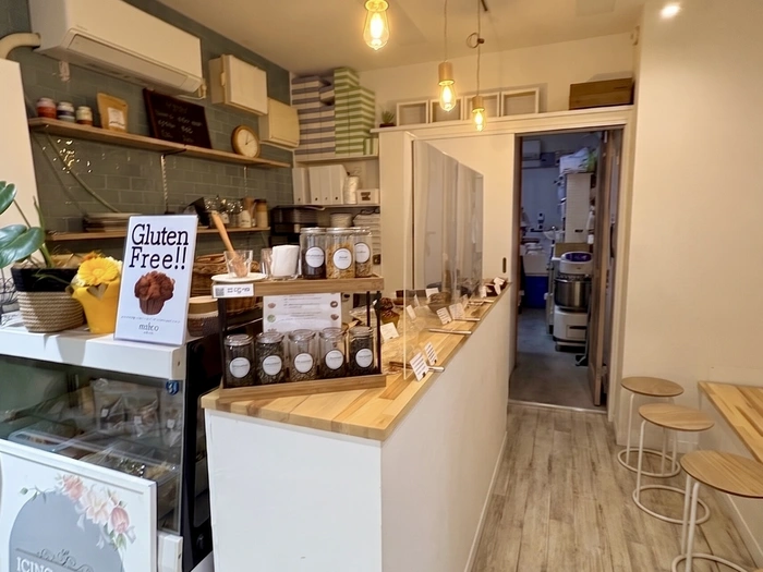 milco sweets の店内カウンター。「Gluten Free!!」のサインの隣に Be By Tea のハーブ瓶が並ぶ