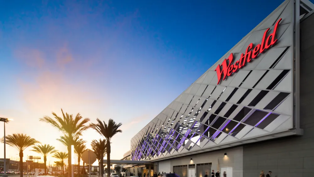 Exterior of a Westfield shopping mall building at sunset.