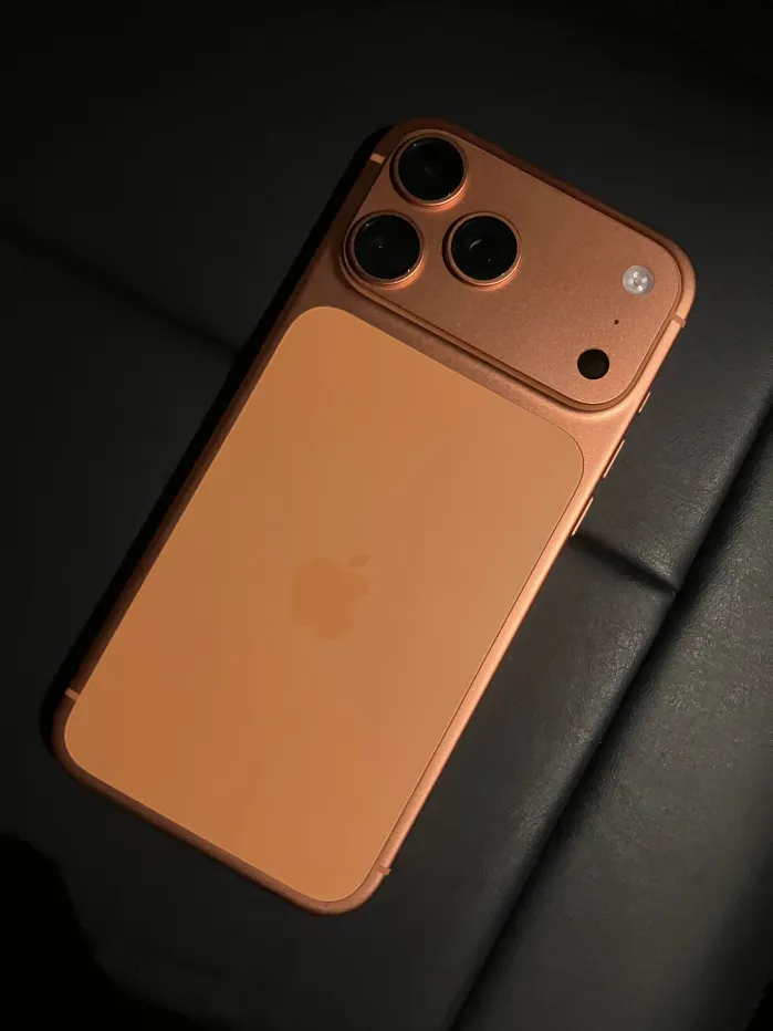 Rear of a bronze-colored smartphone with three cameras