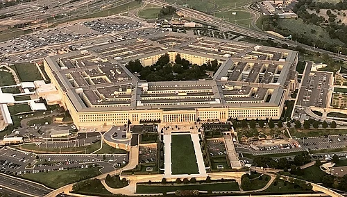 Aerial view of the Pentagon complex and surrounding roads, parking areas, and greenery.