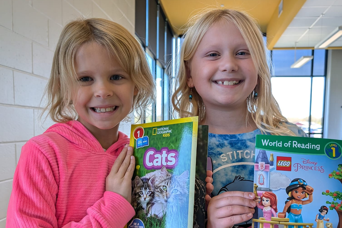 2 kids holding books