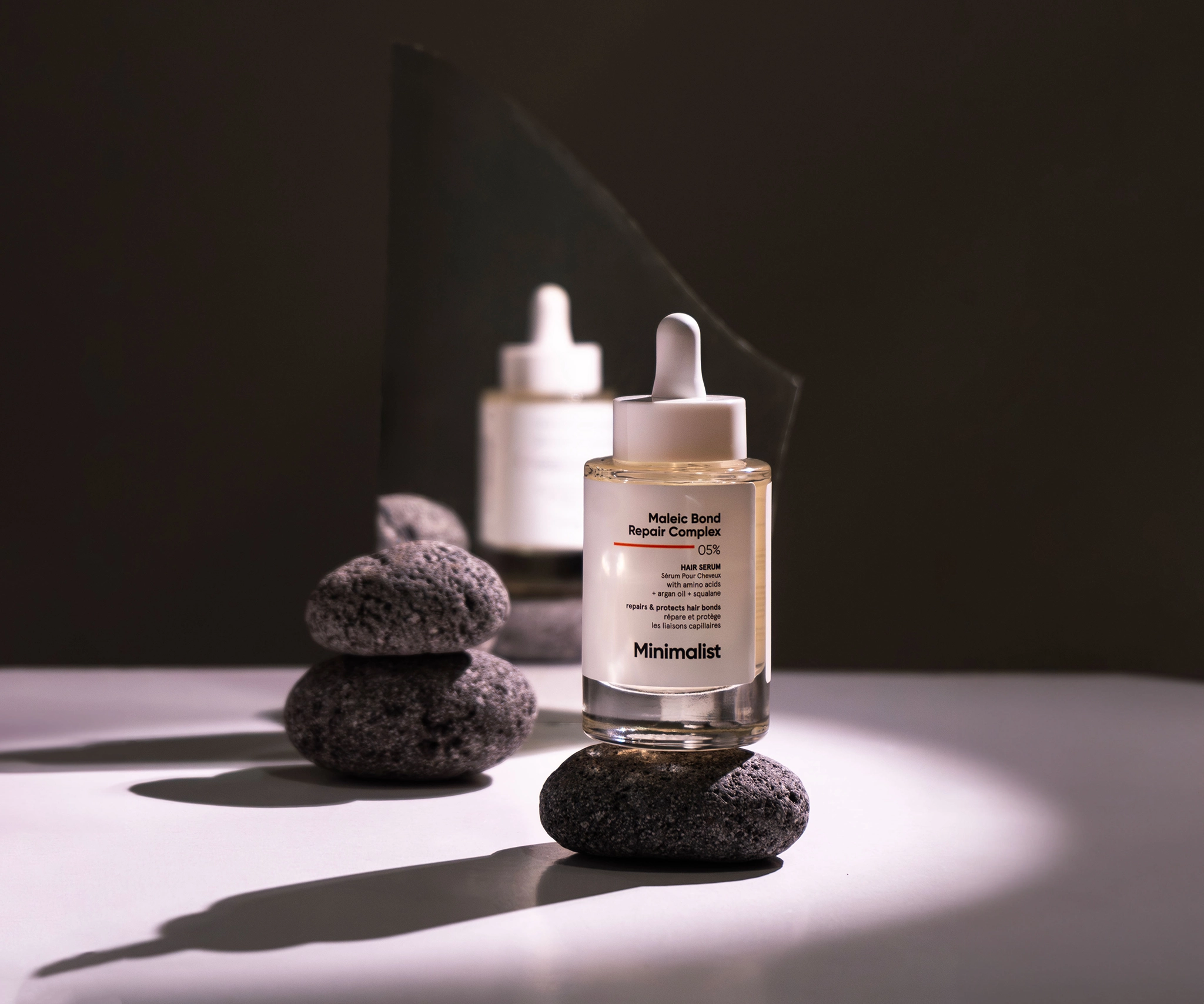 product photography of skincare brand minimalist, photo of the product kept on top of a stone in the left side and on the right, the shadow on the product