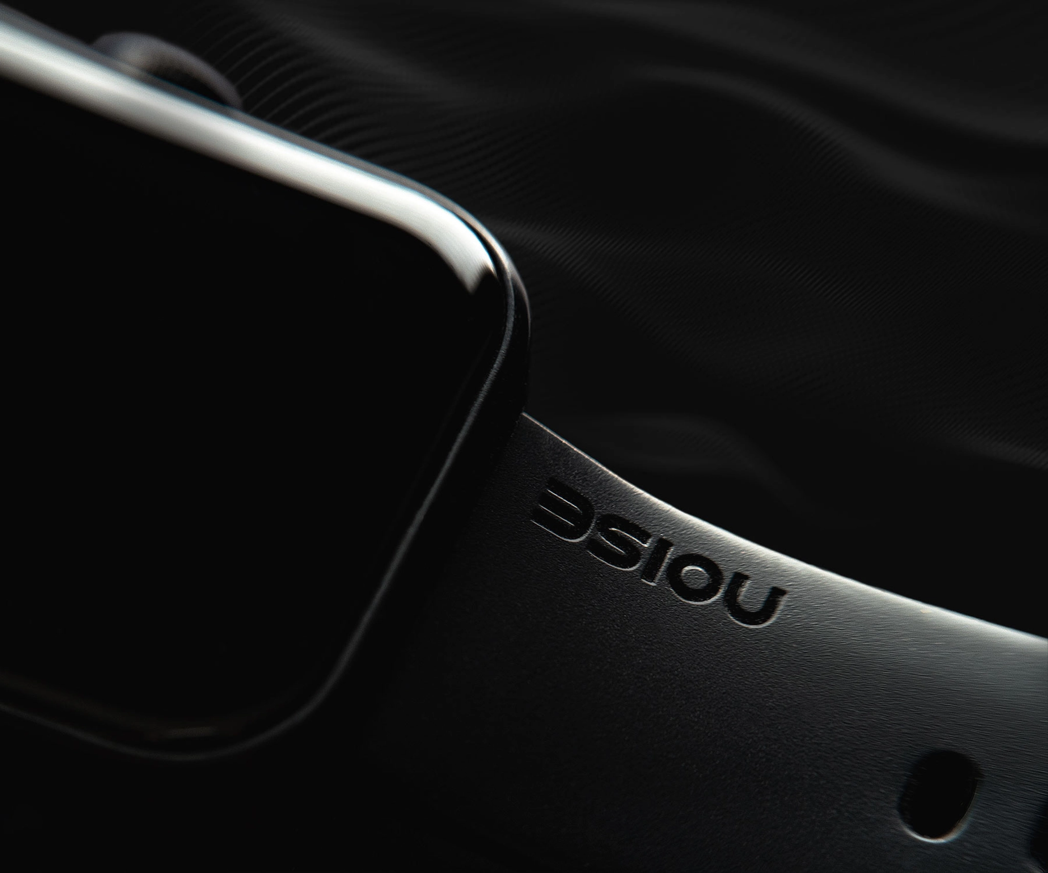 High end commercial photography of noise smartwatch, close up shot of the smartwatch screen and belt with logo on a black background