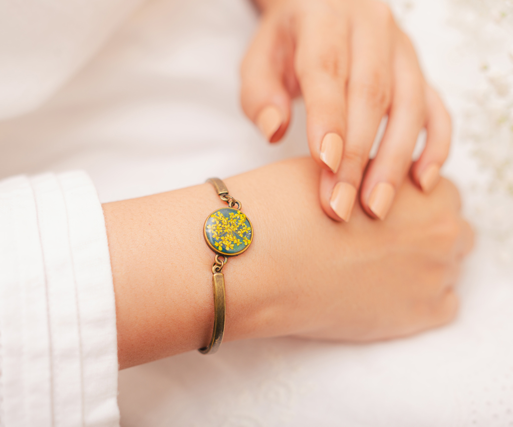 Professional campaign image woman wearing a floral jewelry bracelet. Studio product photography 