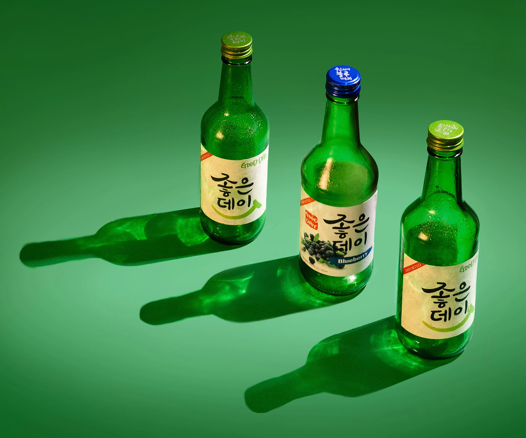 Flatlay image of a soju good day bottle kept around sand to create an underwater set design for a campaign photography. Underwater beach themed shoot for a beverage brand