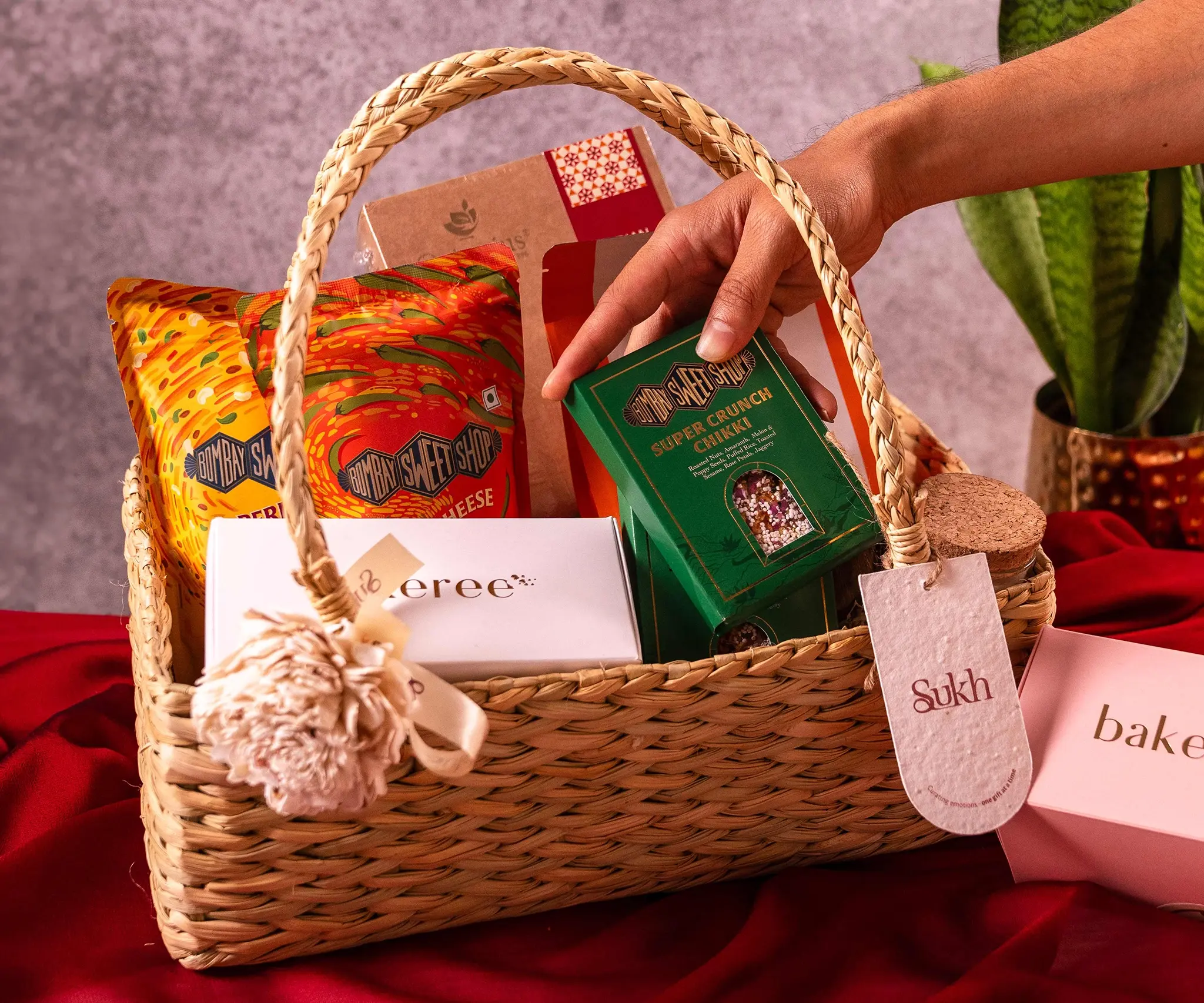 Product photography of a period gift hamper with a bamboo basket and inside that are chocolates by smoor, period heating pads by NUA, chamomile tea, shot in controlled studio environment replicating the winter sun