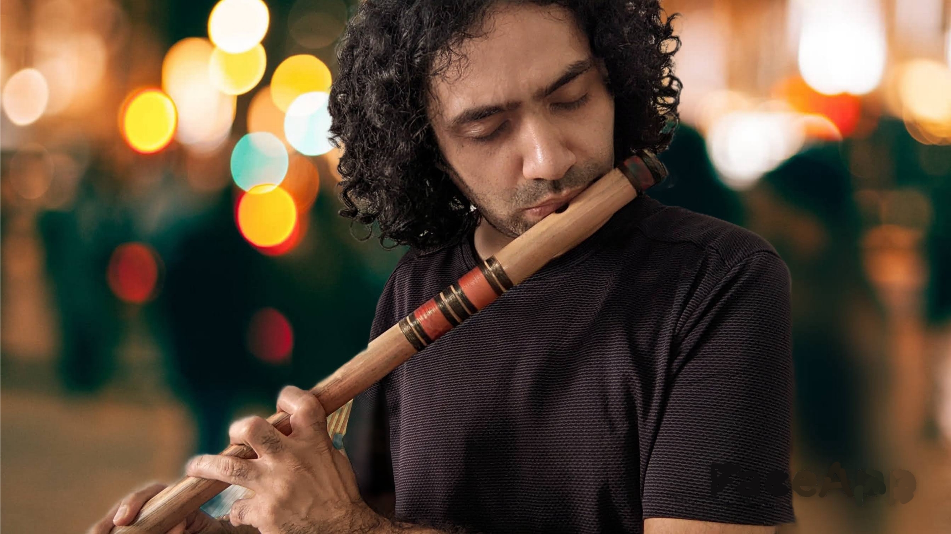 Akshat Mehrotra, Indian Bamboo Flute artist, performing on stage with dramatic lighting