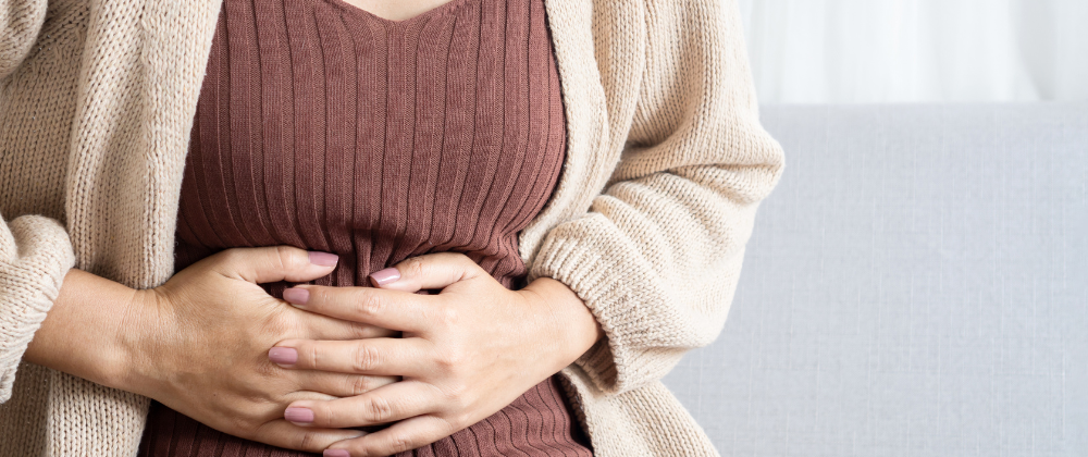 Frau hält ihren Bauch, da Schmerzen