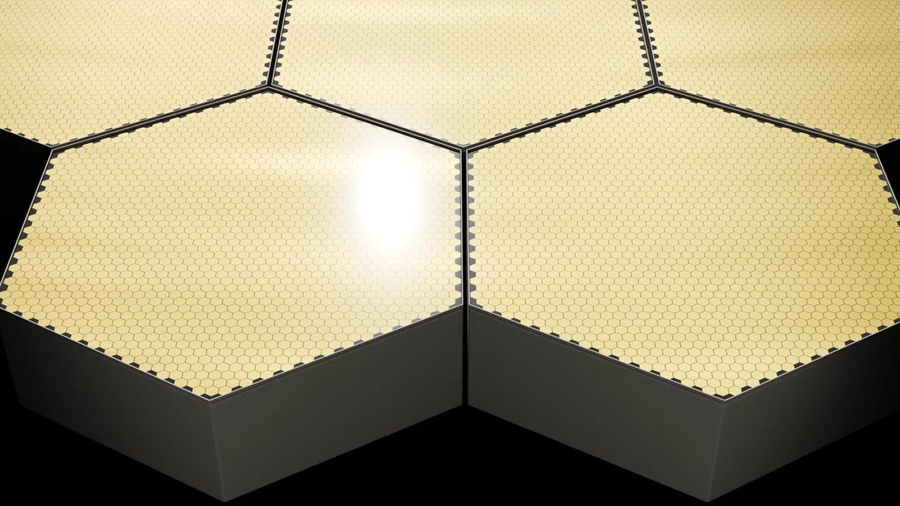 Hexagonal solar panel tiles arranged in a row, with a light reflection on the surface