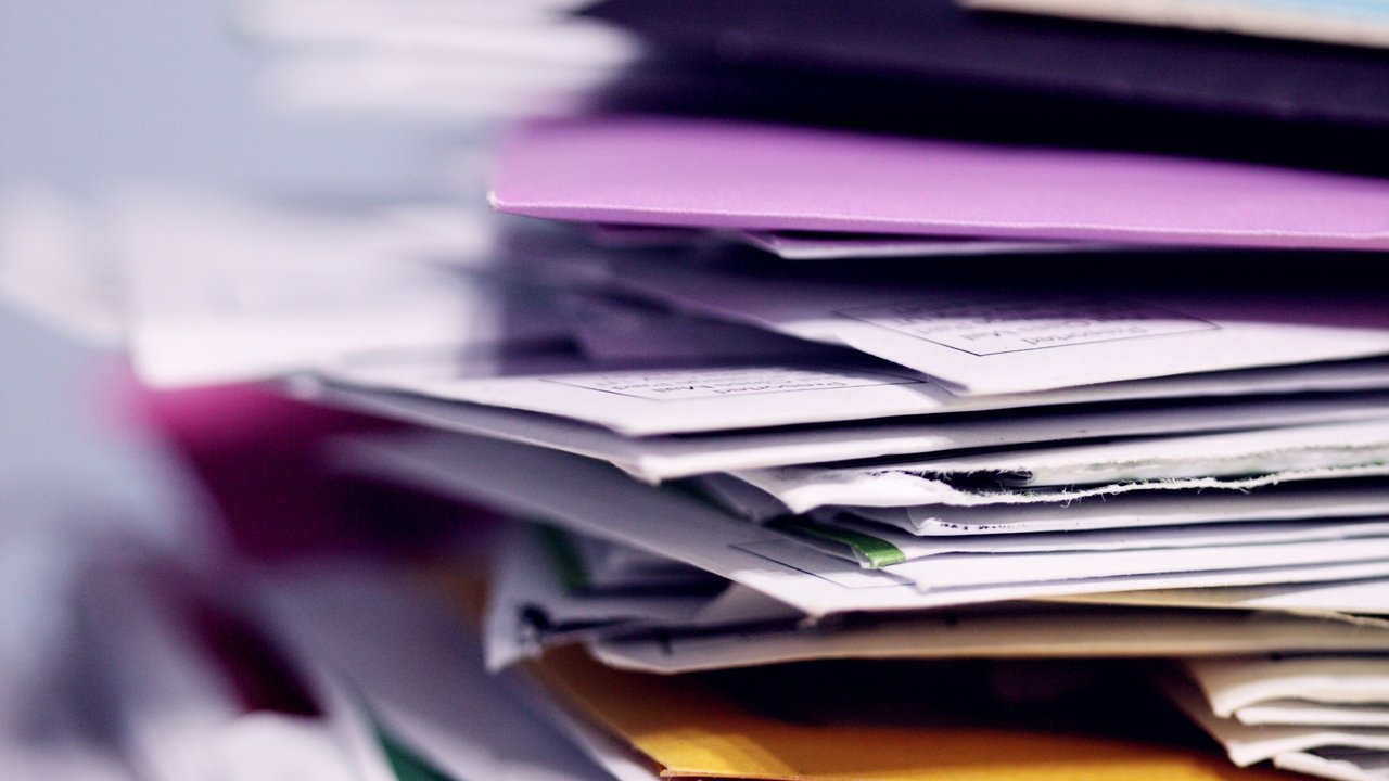 A close-up of a stack of paper sheets and envelopes.