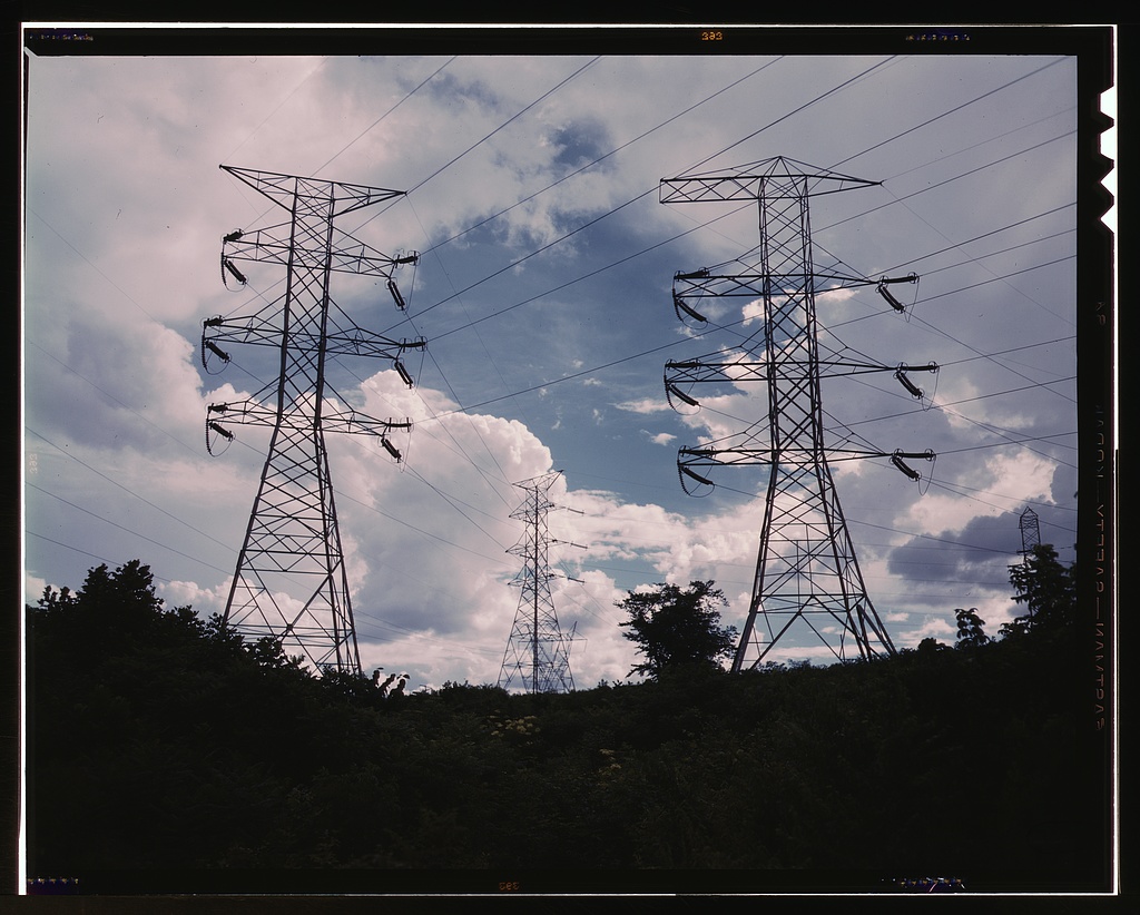 Transmission line towers and power lines against a cloudy sky