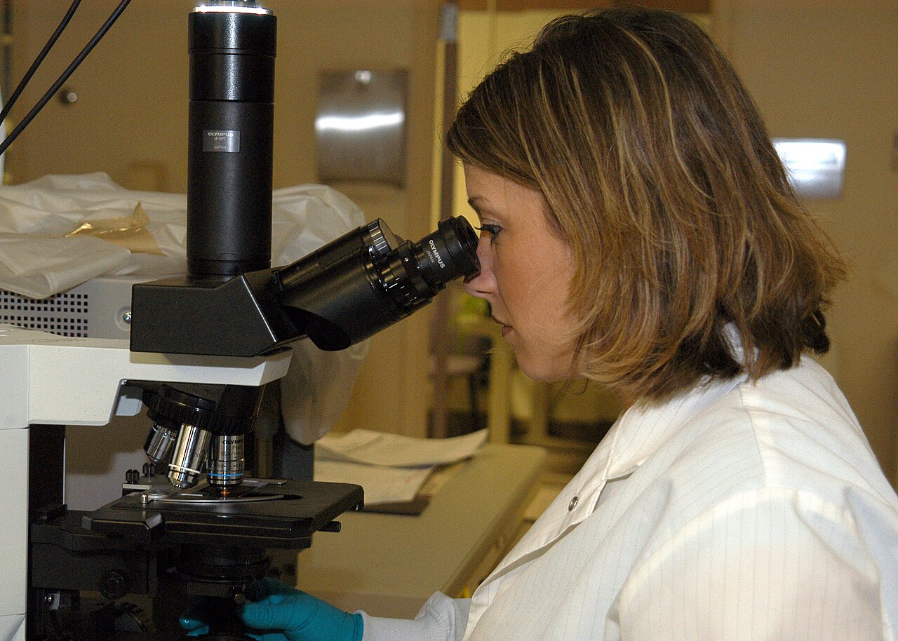 A laboratory technician looking into a microscope