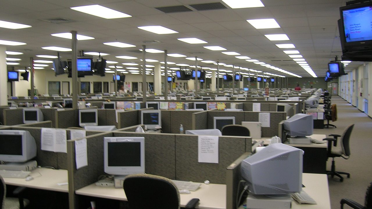 A large open-plan office floor with rows of computer workstations