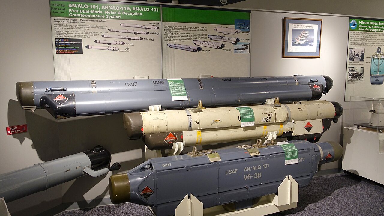 Display of US military electronic countermeasure pods, including AN/ALQ-131 units, in a museum exhibit.