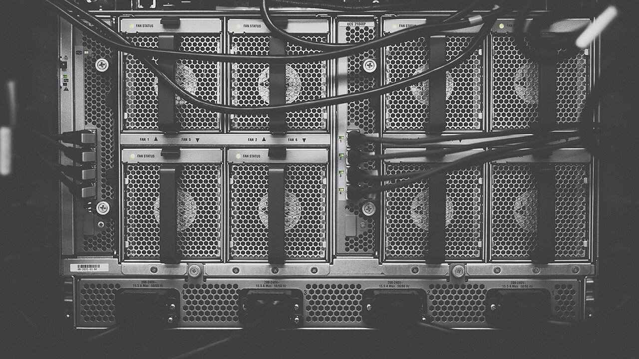 A black-and-white view of a rack-mounted server chassis with cooling fans and cabling