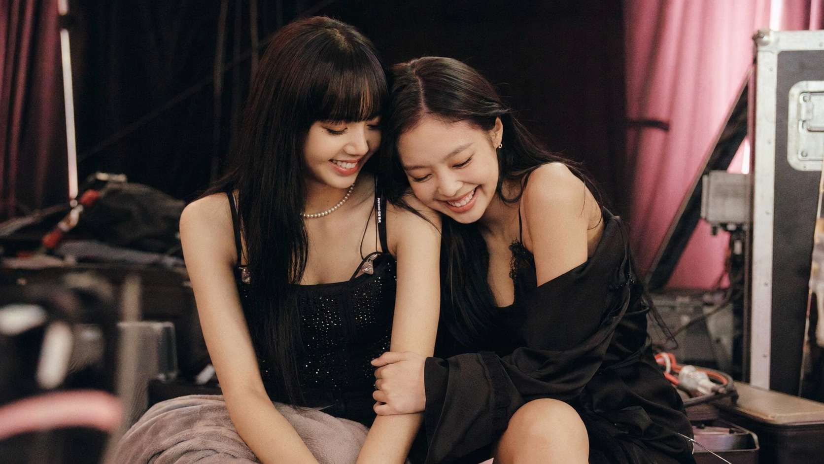 Lisa and Jennie share a warm backstage moment, reflecting the supportive friendship they built during their trainee years.
