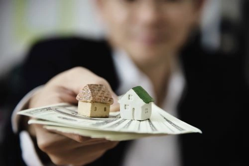 Persona sosteniendo dinero para comprar una casa