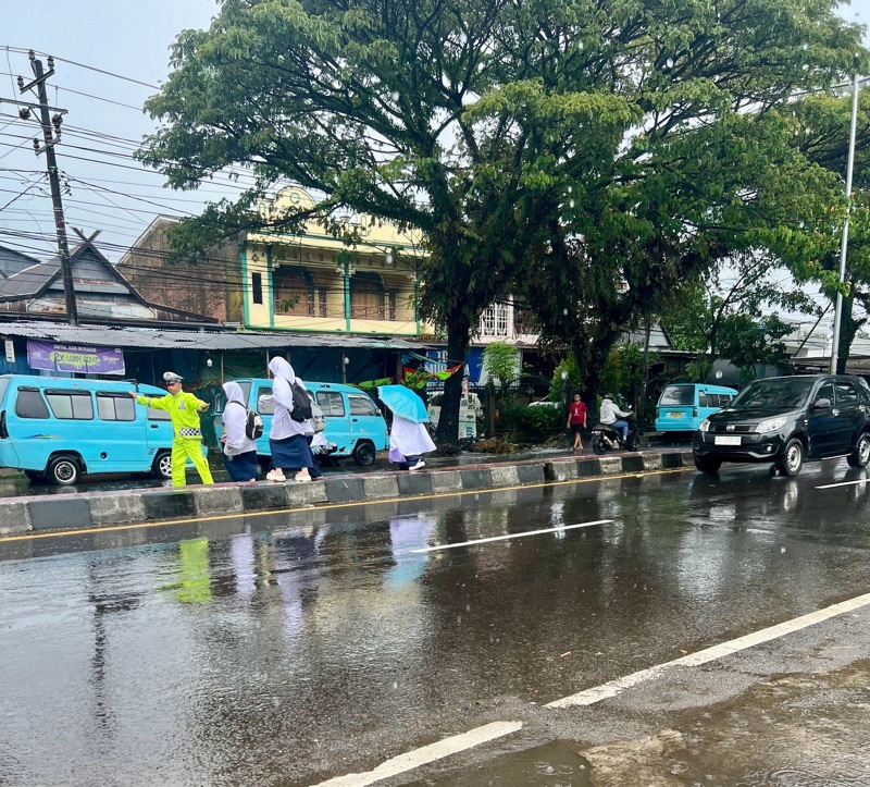 ​Meski Di Guyur Hujan, Personel Polsek Turikale Kabupaten Maros Tetap Semangat Atur Arus Lalu Lintas Di Jam Bubaran Anak Sekolah